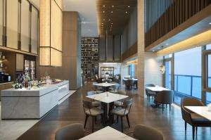 a restaurant with tables and chairs and a bar at Yantai Marriott Hotel in Yantai