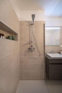 y baño con ducha y lavamanos. en Le Square d'Evan - Appartement de Standing - Grande Terrasse Extérieure - Climatisation, en Saint-Aunès