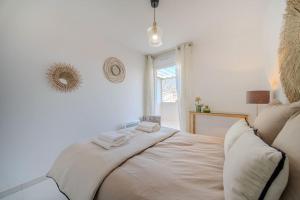 1 dormitorio con 1 cama con sábanas blancas y ventana en Le Square d'Evan - Appartement de Standing - Grande Terrasse Extérieure - Climatisation, en Saint-Aunès