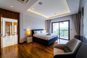 1 dormitorio grande con 1 cama y balcón en Luxury Mansion On Golf Course BMG5, en Hua Hin