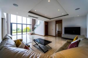 a large living room with a couch and a tv at Luxury Mansion On Golf Course BMG5 in Hua Hin