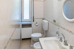 uma casa de banho com um WC, um lavatório e uma janela em La Casa di Sissi em La Spezia
