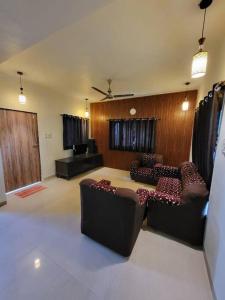 a living room with two couches and a table at THE PERFECT STAYS: SUPREME BLISS VILLA in Lonavala