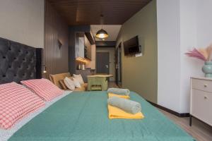 a bedroom with a large green bed with towels on it at Urban Jungle apartament Epsilon in Białystok