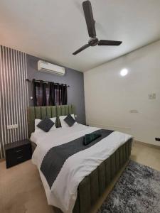 a bedroom with a large bed with a ceiling fan at THE PERFECT STAYS: SUPREME BLISS VILLA in Lonavala
