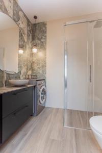 een badkamer met een wastafel en een wasmachine bij Urban Jungle apartament Epsilon in Białystok
