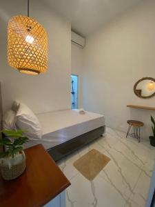 ein Wohnzimmer mit einem weißen Sofa und einem Tisch in der Unterkunft Emerald Guest House type kansas Purwokerto in Banyumas