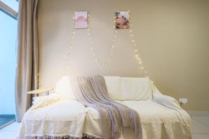 a bedroom with a white bed with lights on the wall at Tranquil Retreats in Kuala Lumpur