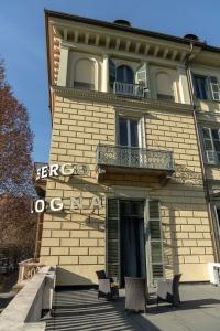 un bâtiment avec un balcon et des chaises en face de celui-ci dans l'établissement Hotel Bologna, à Turin