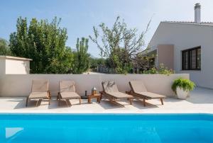 un grupo de sillas sentadas junto a una piscina en Relax Villa Tanasia with a pool near Split, en Kaštela