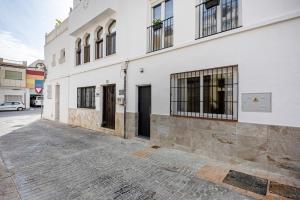 un edificio blanco con puertas y ventanas en una calle en Agua Viva Mar en Málaga