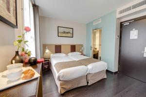 a bedroom with a bed and a table with a plate of food at Source Hôtel in Paris