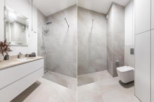 een badkamer met een douche, een toilet en een wastafel bij SuperApart Stanisława Augusta 42 in Warschau