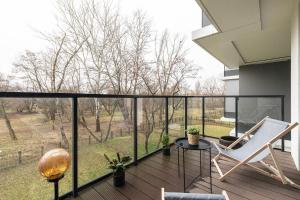 een kamer met een balkon met een stoel en een tafel bij SuperApart Stanisława Augusta 42 in Warschau