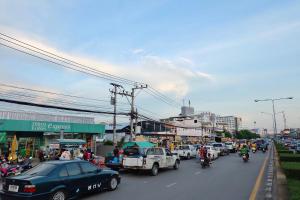 una concurrida calle de la ciudad llena de coches y motocicletas en U-Thong Hotel, en Phitsanulok