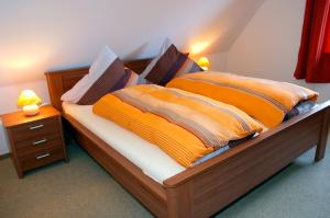a bedroom with a bed with orange and brown sheets at Rote Koje in Dagebüll