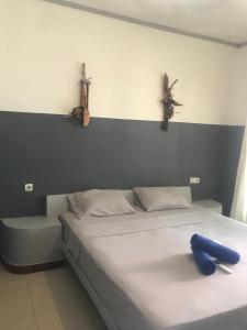 sypialnia z łóżkiem z niebieskim przedmiotem w obiekcie Bintang Guesthouse w Gili Trawangan