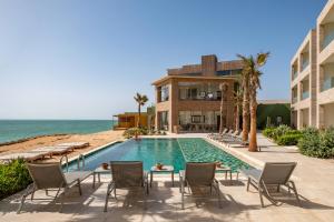 a swimming pool next to a building and the ocean at Dakhla South Bay in Dakhla