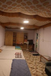 a room with a large bed and a ceiling at Ramu Green Lake Cottage in Mysore