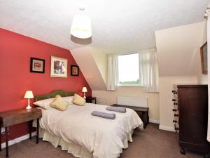 a bedroom with a bed and a red wall at 3 Bed in Great Snoring KT075 in Great Snoring