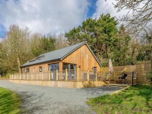 a large wooden cabin with a black roof at 2 Bed in Bude 66127 in North Tamerton
