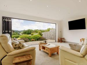 a living room with two couches and a large window at 3 Bed in Bovey Tracey 64380 in Bovey Tracey