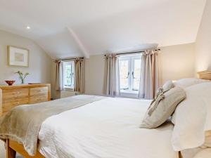 a bedroom with a large white bed and windows at 1 Bed in Marlborough 65123 in Fyfield