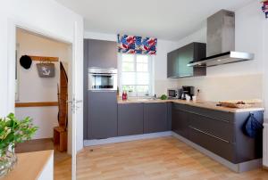 uma cozinha com armários cinzentos e uma janela em Ahlbecker Höhe App Strandkorb em Ahlbeck