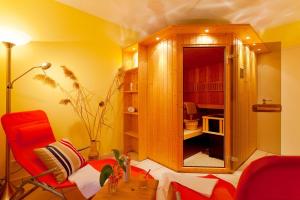 ein Wohnzimmer mit einem roten Stuhl und einem Schrank in der Unterkunft Ahlbecker Höhe App Möwennest in Ahlbeck