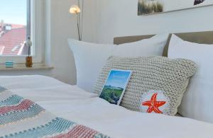 ein Bett mit einem Kissen und einem Buch darauf in der Unterkunft Ahlbecker Höhe App Möwennest in Ahlbeck