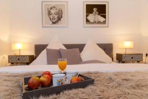 uma bandeja de frutas e um copo de sumo de laranja numa cama em Quartier Nr 6 App 1 em Bansin