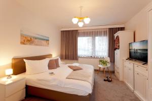 um quarto com uma cama grande e uma televisão de ecrã plano em Quartier Nr 6 App 1 em Bansin
