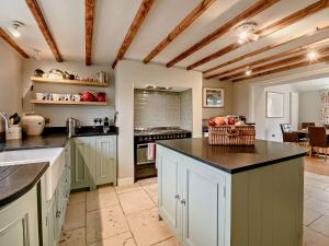 a large kitchen with white cabinets and black counter tops at 4 Bed in York G0091 