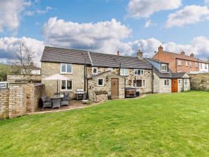 a large stone house with a lawn in front of it at 4 Bed in York G0091 