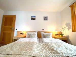 una camera da letto con un grande letto bianco con due cuscini di Süderhaus Hiddensee App 4 a Neuendorf