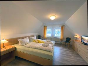 a bedroom with a bed and a desk and a television at Süderhaus Hiddensee App 12 in Neuendorf