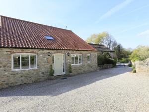 a stone house with a red roof and a gravel driveway at 3 Bed in Bedale G0095 in Crakehall