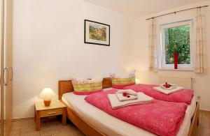 ein Schlafzimmer mit einem roten Bett mit Handtüchern darauf in der Unterkunft Usedom Ahoi App 4 in Heringsdorf