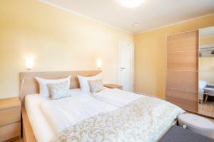 - une chambre avec un grand lit blanc dans l'établissement Residenz Sonnenhof App 30, à Bansin