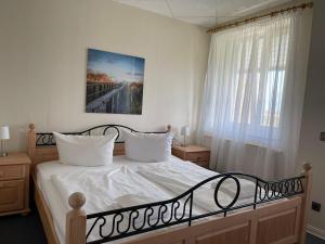 1 dormitorio con 1 cama grande con sábanas blancas en Süderhaus Hiddensee App 15, en Neuendorf