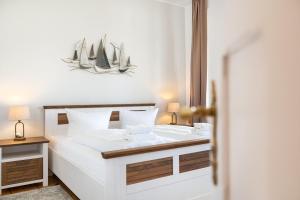 a bedroom with a large white bed with two lamps at Villa Albus App 4 in Ahlbeck