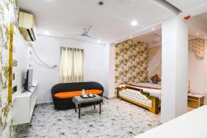 a bedroom with a bed and a tv and a table at FabHotel Prime Rockstar in Ballygunge