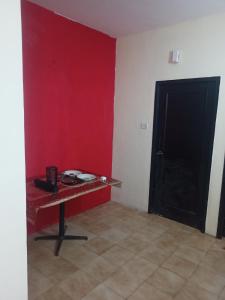 a room with a table and a red wall at Holiday home in Ooty