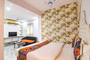 a hotel room with a bed and a chair at FabHotel Prime Rockstar in Ballygunge