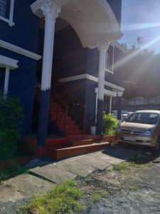 a car parked in front of a house with columns at Holiday home in Ooty
