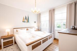 um quarto branco com uma cama grande e uma janela em Villa Albus App 8 em Ahlbeck