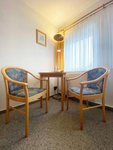 a room with two chairs and a table and a window at Süderhaus Hiddensee App 6 in Neuendorf