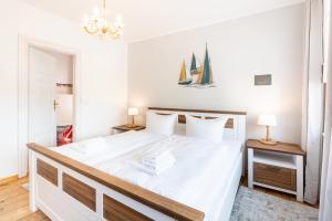 um quarto com uma grande cama branca com velas na parede em Villa Albus App 8 em Ahlbeck