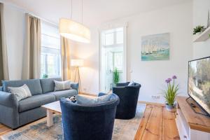 ein Wohnzimmer mit einem Sofa und einem Tisch in der Unterkunft Villa Albus App 2 in Ahlbeck