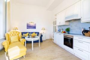 una cucina con sedia gialla e tavolo di Villa Gruner App 1a a Zinnowitz